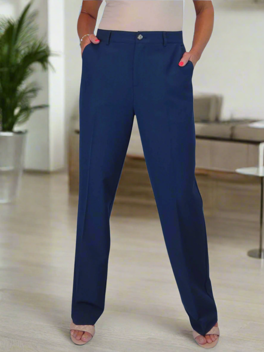 Person wearing blue pants in a room with a plant and furniture.